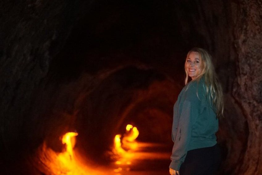 A person standing in a cave with glowing orange lights. 5