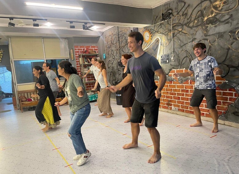 A dance class in a room with graffiti and brick walls. 4