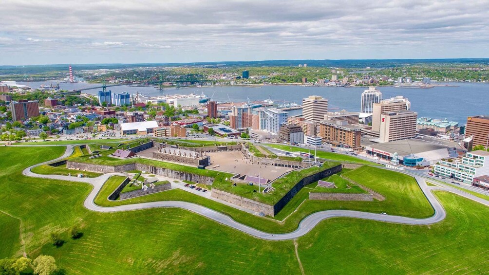 An aerial view of a city with a prominent historical fort, modern buildings, and a waterfront. 2