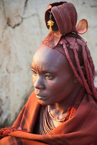 A person wearing a red garment and a headpiece with a bell. 5