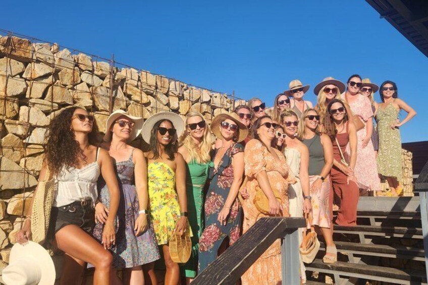 A group of people standing in front of a stone wall. 1