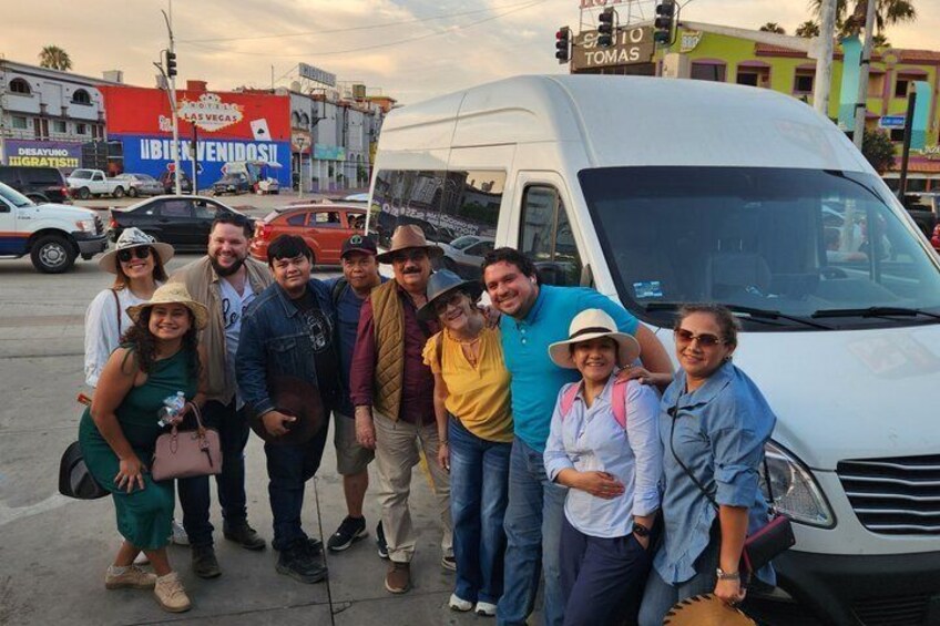 A group of people posing in front of a white van with a sign that reads 'UBICENOVOS' and 'TOMAS' on it. 3