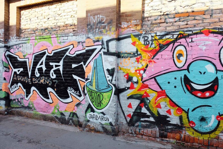 A wall with colorful graffiti, including a large 'VIBE' text and a cartoonish face. 2