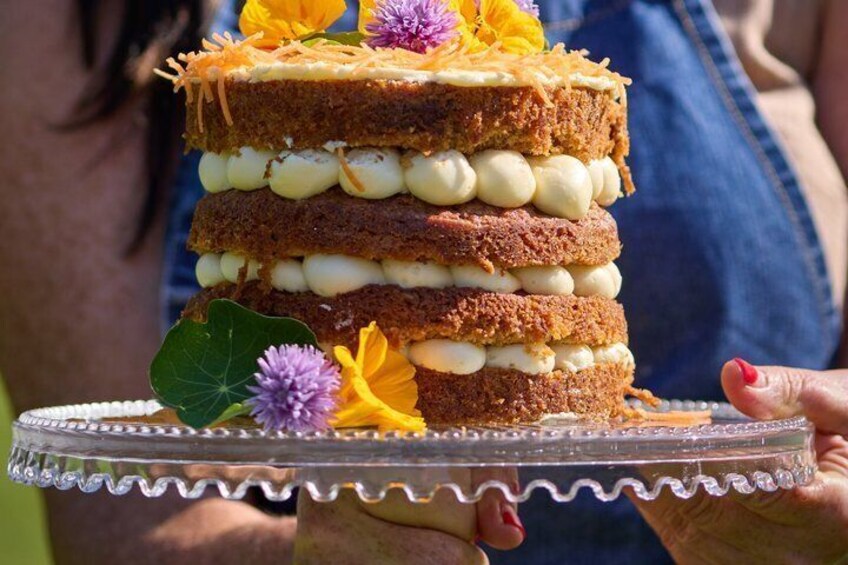 A layered cake with cream and decorated with flowers. 5