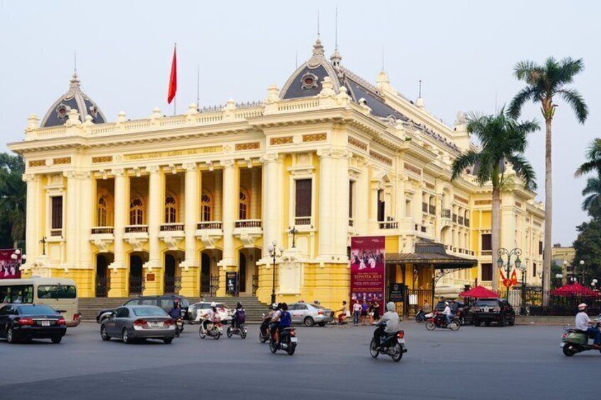 A large, ornate building with a red flag, surrounded by palm trees and busy traffic. 4