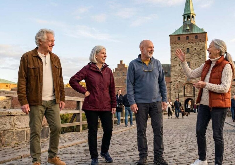 Four people standing on a cobblestone path with a historic tower in the background. 5