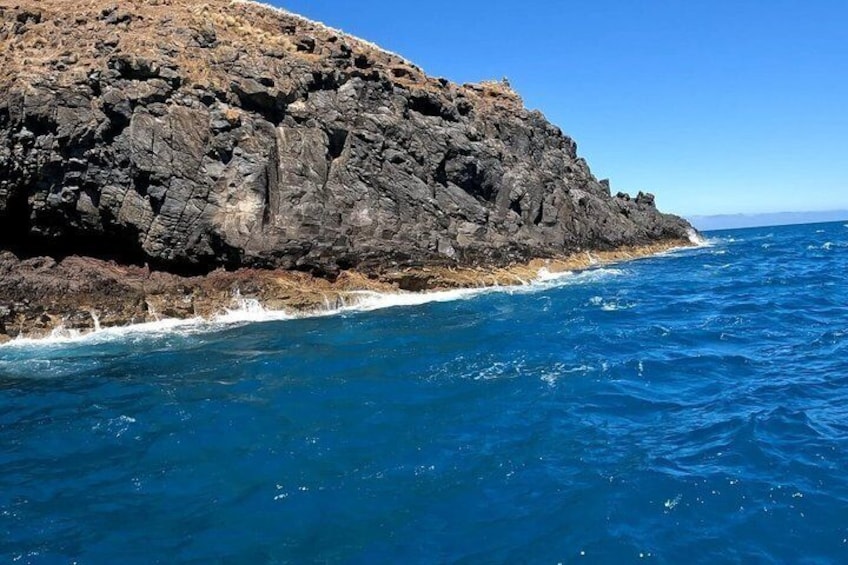 A rocky coastline with clear blue ocean waters. 4