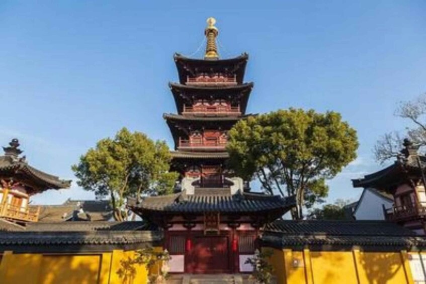 A traditional multi-tiered pagoda with a golden spire, surrounded by trees and traditional architecture. 3