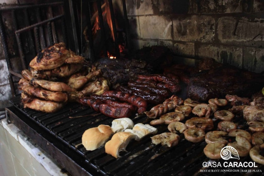 A variety of meats grilling on a barbecue, including sausages, steaks, and mushrooms. 5