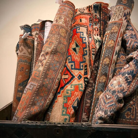 A collection of intricately patterned textiles displayed on a shelf. 4