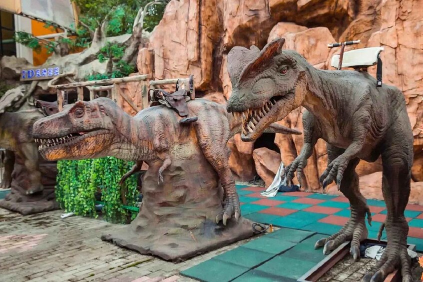 A dinosaur exhibit with life-sized models of various dinosaurs. 3