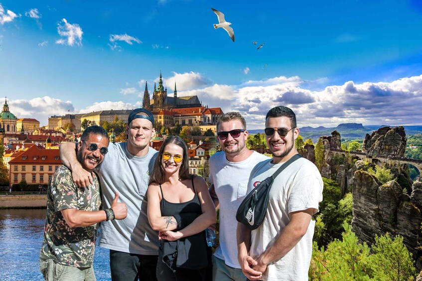 A group of people standing in front of a historic cityscape with a river, a prominent church, and rock formations. 4