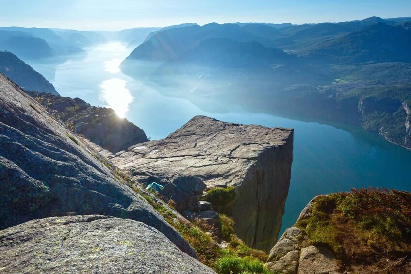 A mountainous landscape with a narrow water passage and a rocky cliff. 1