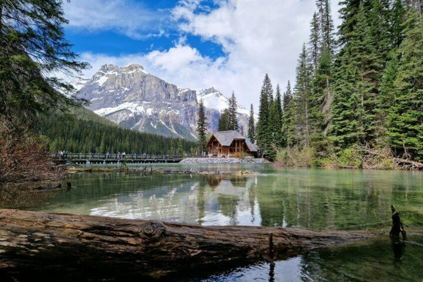 A cabin by a lake with mountains in the background. 5