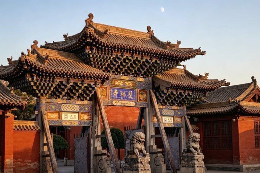 A traditional Chinese building with ornate roofs and lion statues at the entrance. 3