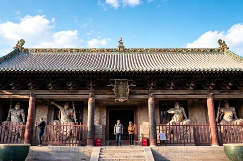 A traditional Chinese building with ornate roof, statues, and a large green pot in the foreground. 4