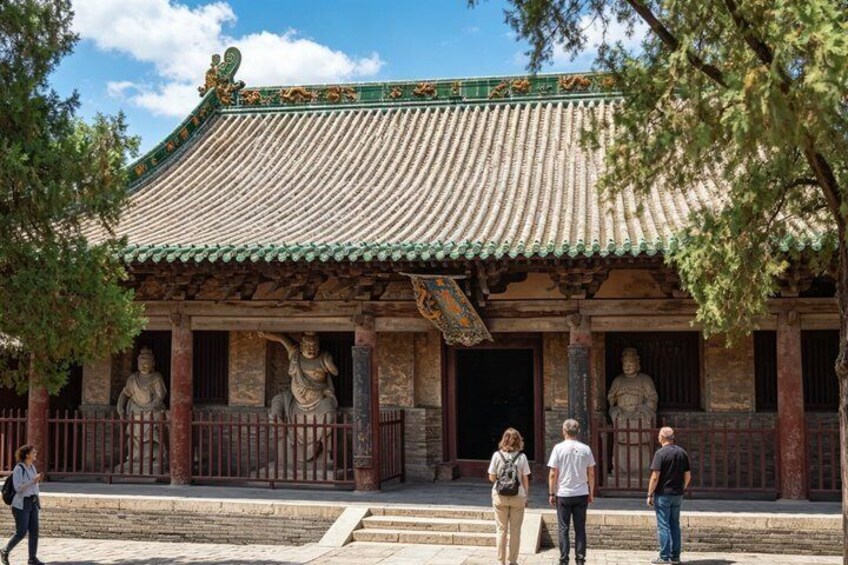 A traditional Chinese building with a tiled roof and statues. 5