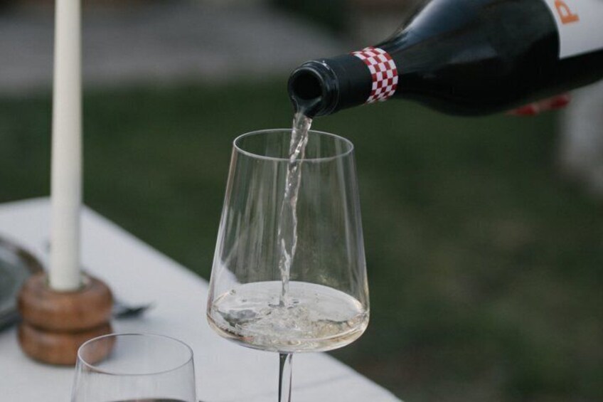 A bottle of wine being poured into a glass. 4