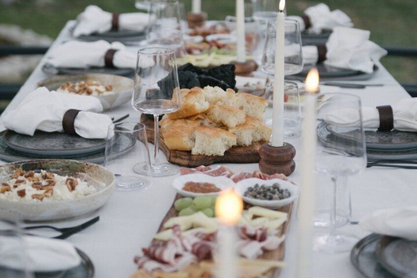 A table set for a meal with various dishes, glasses, and candles. 5