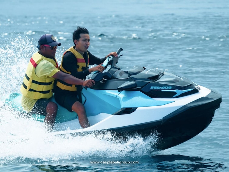 Kaksi henkilöä Sea-Doo -tyyppisellä vesiskootterilla. 2