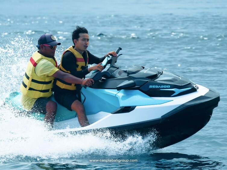Zwei Personen auf einem Jetski fahren im Meer. 2