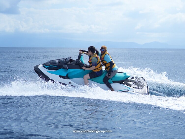 Eine Person fährt mit einem Sea-Doo Jet-Ski über das Wasser, im Hintergrund sind Berge zu sehen. 3