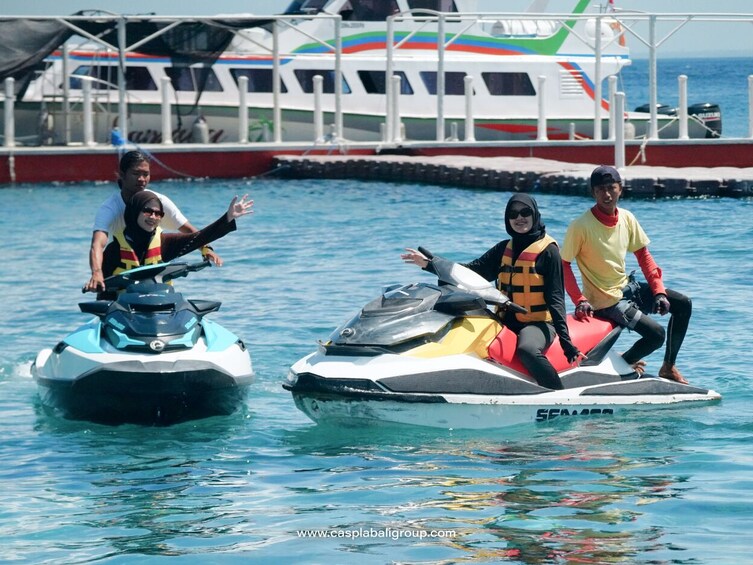 Zwei Personen auf Jetskis, im Hintergrund ein Boot. 5