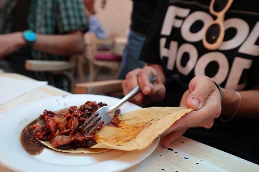 A person holding a plate with food and a fork. 2