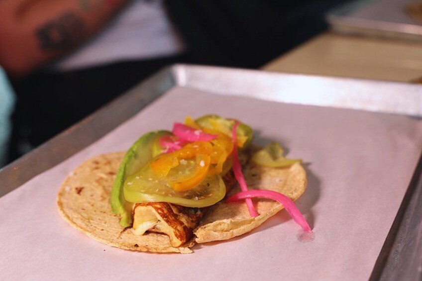 A taco with toppings on a paper-lined tray. 1