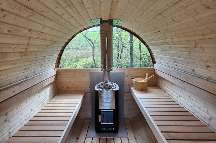 A sauna with wooden benches and a central heating unit. 5