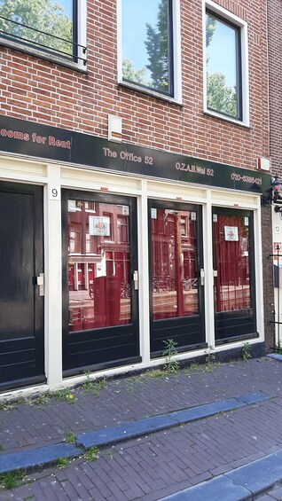 A building with a sign 'The Office 52' and 'O.Z.A.B.Wal 52' with a phone number. 2