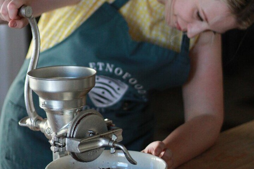 A person operating a manual coffee grinder. 4