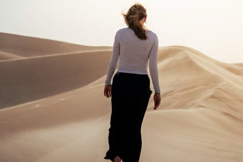 A person walking on sand dunes. 1