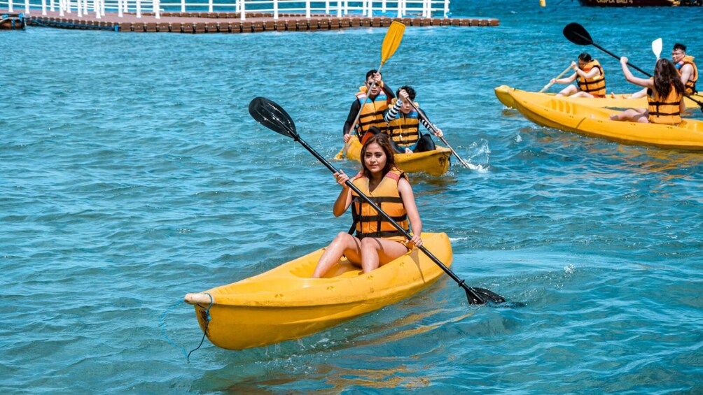 People kayaking on a calm body of water. 2