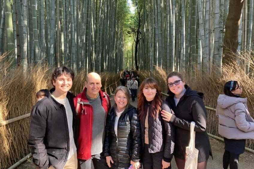 A group of people standing in a bamboo forest. 1