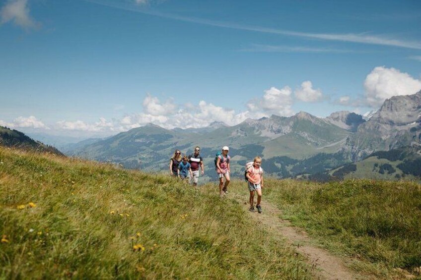A group of hikers on a mountain trail with a view of distant mountains. 4
