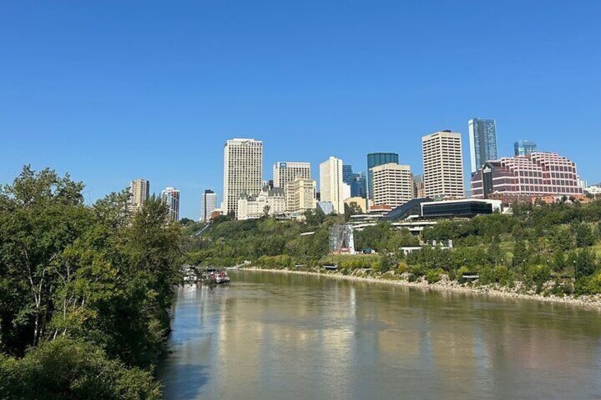 A river with a city skyline in the background, including several high-rise buildings and a bridge. 4