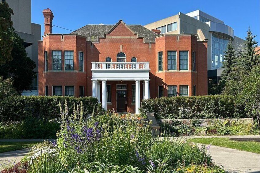 A red brick building with a white entrance and a garden in front. 3