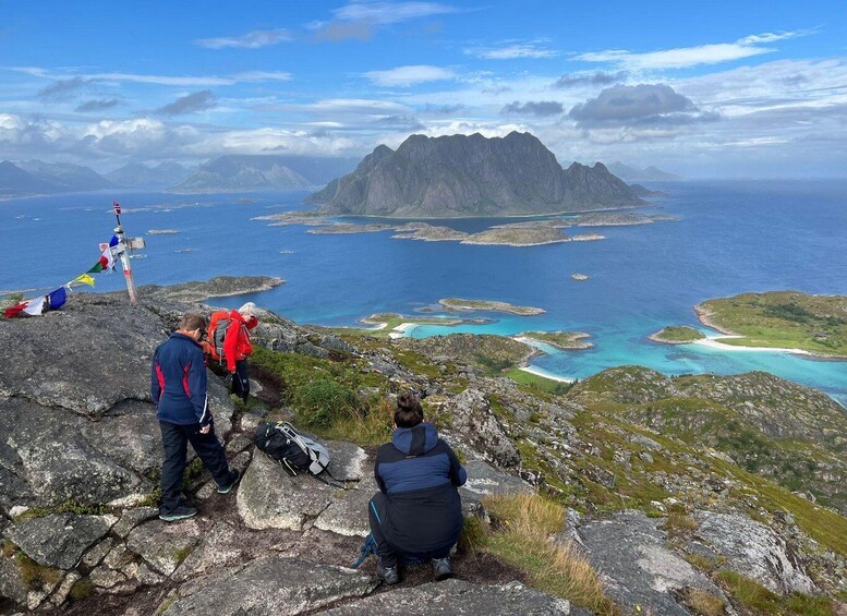 Hikers on a rocky mountain with a view of a coastal archipelago. 4