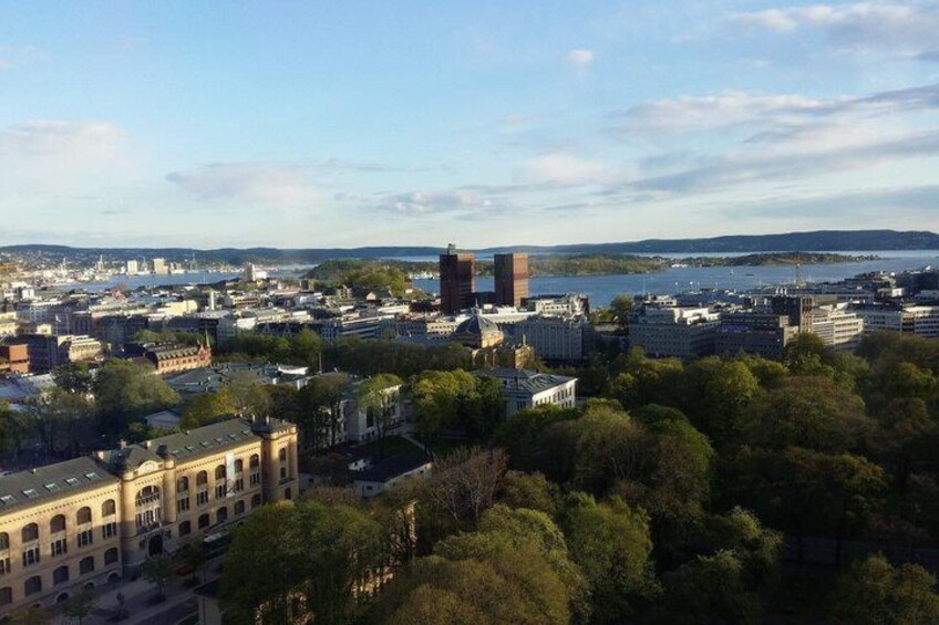 A cityscape with a prominent building, a body of water, and surrounding greenery. 2