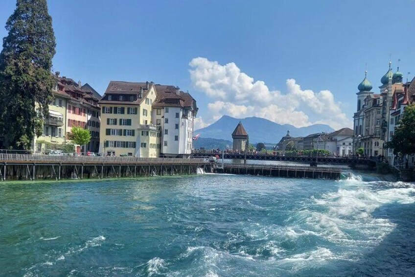 A river with buildings and a mountain in the background. 3