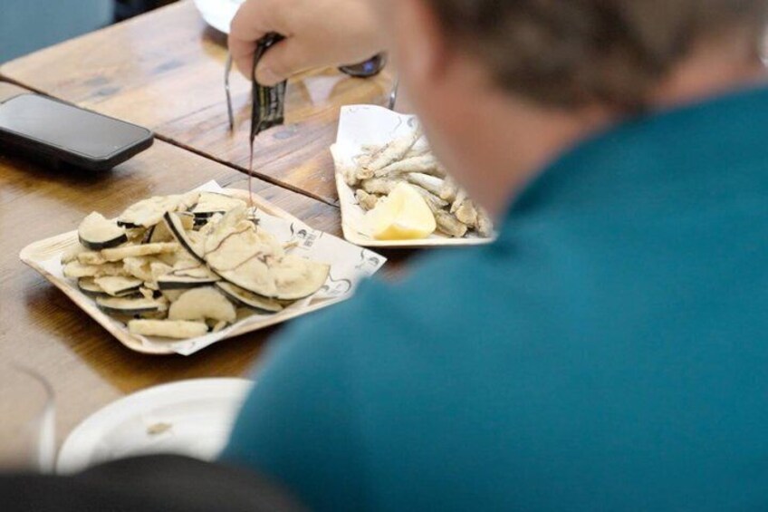 A person cutting mushrooms on a wooden table. 1