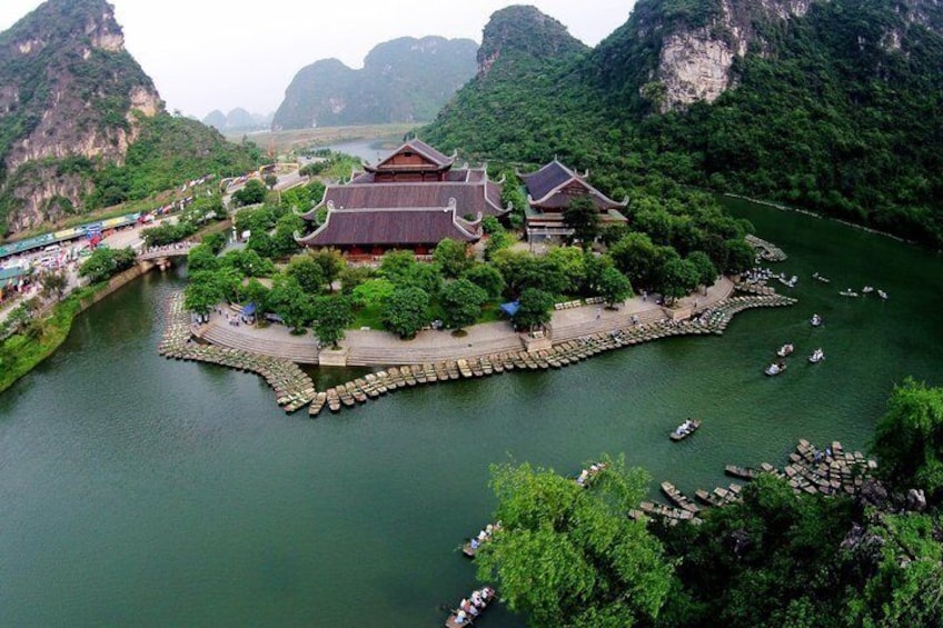 A traditional Chinese building by a river with boats docked. 4
