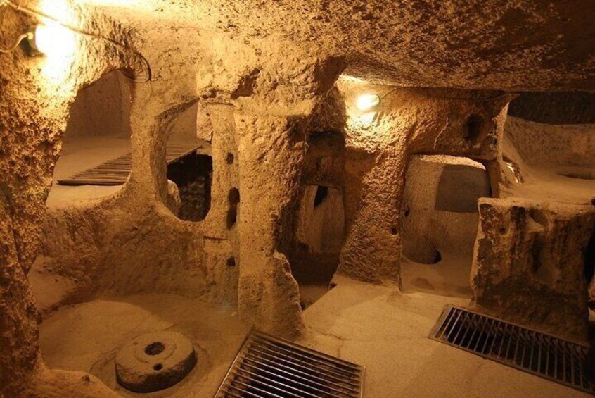 A cave interior with stalactites, a water drainage system, and artificial lighting. 1