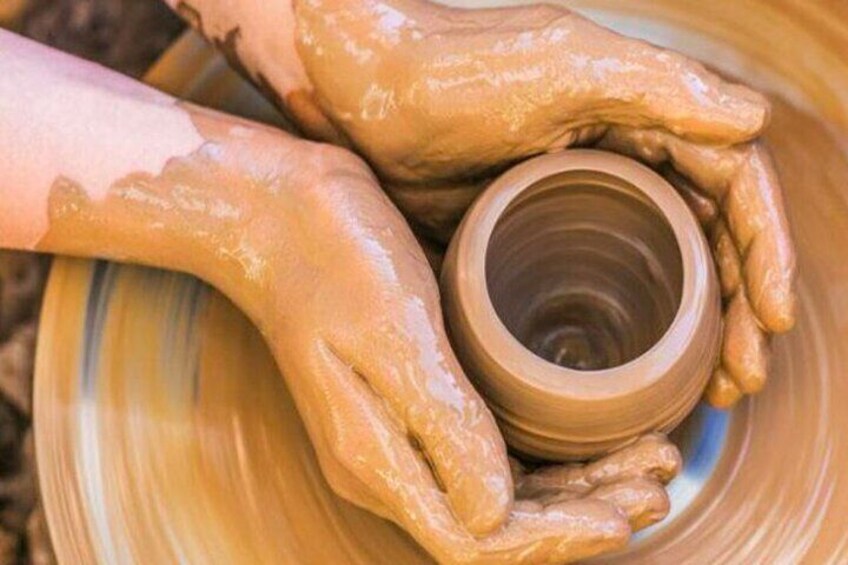 Hands shaping a clay pot on a spinning wheel. 2