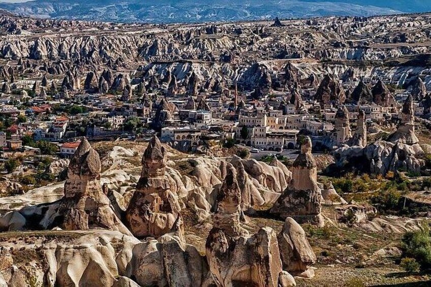 A landscape with prominent rock formations and a town in the background. 2