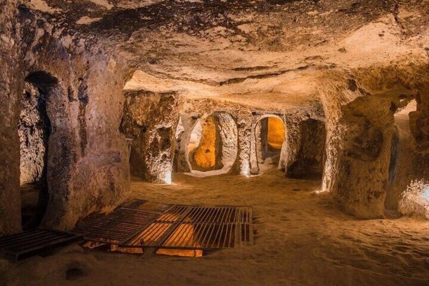 A cave interior with stalactites, a wooden platform, and a central opening. 4
