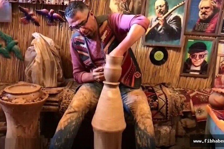 A person crafting pottery in a workshop with tools and pottery wheels. 3