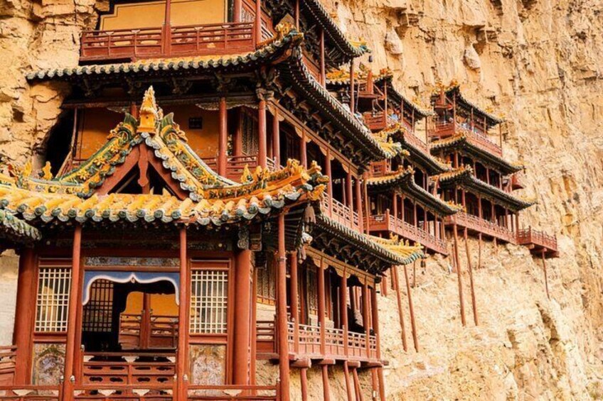 A traditional Chinese temple with ornate architecture built into a cliffside. 3