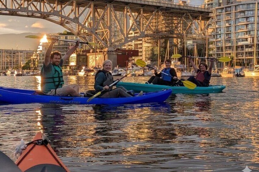 People kayaking on a river with a bridge in the background. 2